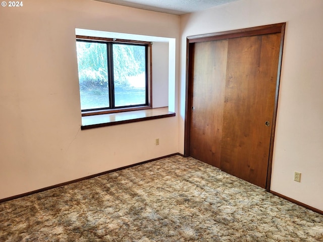 unfurnished bedroom featuring a closet, a textured ceiling, and carpet floors