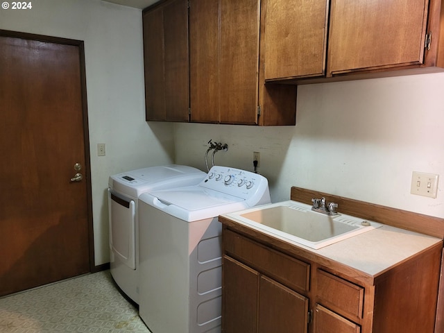 laundry area with sink, washer and dryer, and cabinets