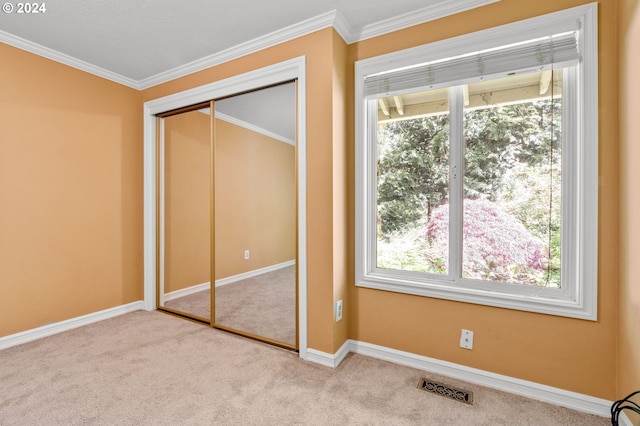 unfurnished bedroom featuring crown molding, a closet, and light colored carpet