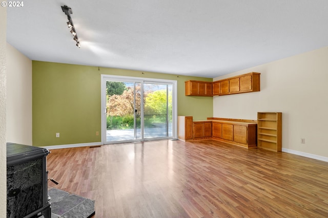 interior space with hardwood / wood-style floors, a wood stove, and rail lighting