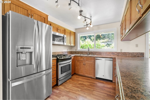 kitchen featuring stainless steel appliances, hardwood / wood-style flooring, sink, and rail lighting