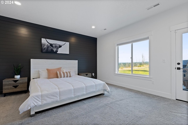 bedroom with carpet and wood walls