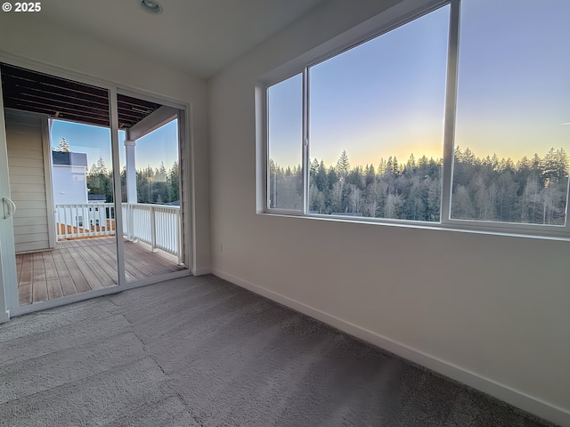 carpeted spare room featuring baseboards