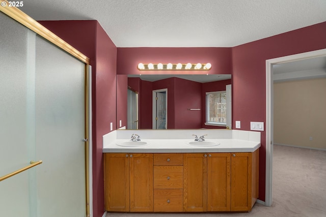 bathroom featuring a textured ceiling, vanity, and a shower with shower door