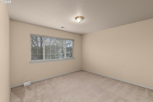 carpeted spare room featuring a textured ceiling