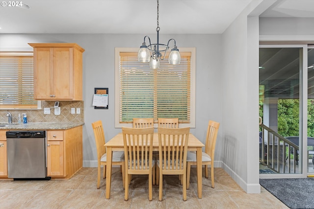 tiled dining space with sink and a chandelier