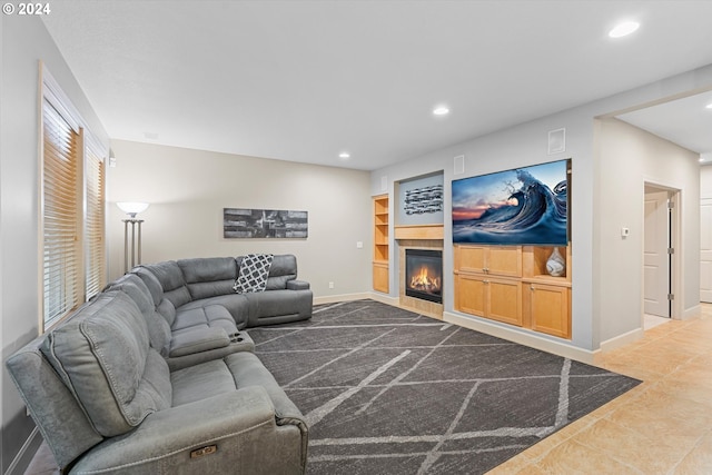 living room featuring tile patterned floors, built in shelves, and a healthy amount of sunlight