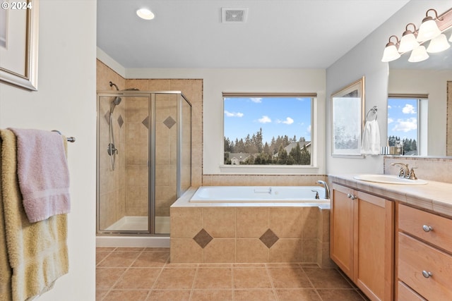 bathroom with tile patterned floors, vanity, a healthy amount of sunlight, and separate shower and tub