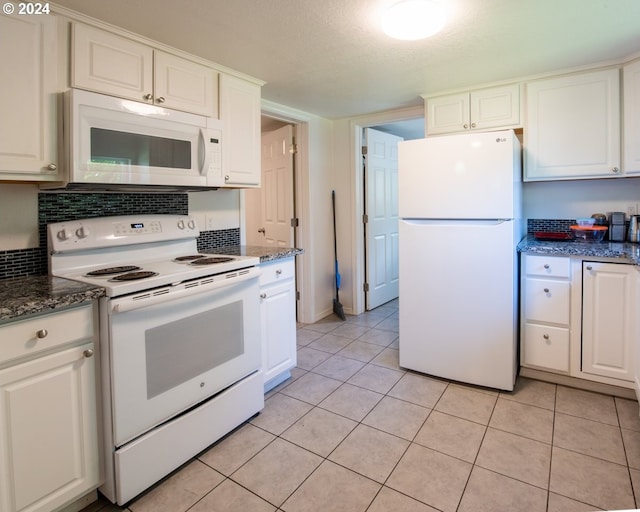 kitchen featuring a textured ceiling, white cabinets, light tile patterned flooring, and white appliances