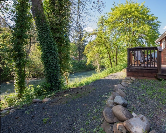 view of yard with a deck with water view