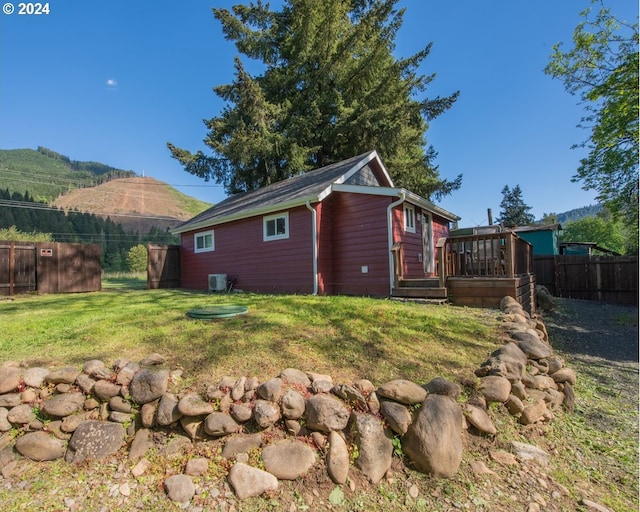 rear view of house featuring a yard and a deck with mountain view