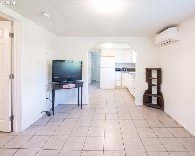 kitchen featuring white cabinets, white refrigerator, light tile patterned floors, and a wall mounted AC