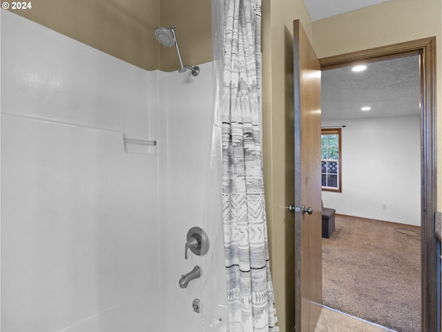 bathroom with tile patterned floors, shower / bath combo, and a textured ceiling