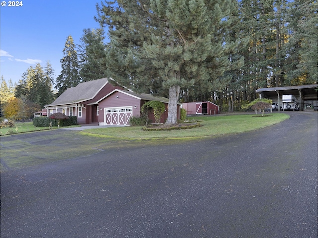 view of front facade featuring a front yard, a carport, and an outdoor structure