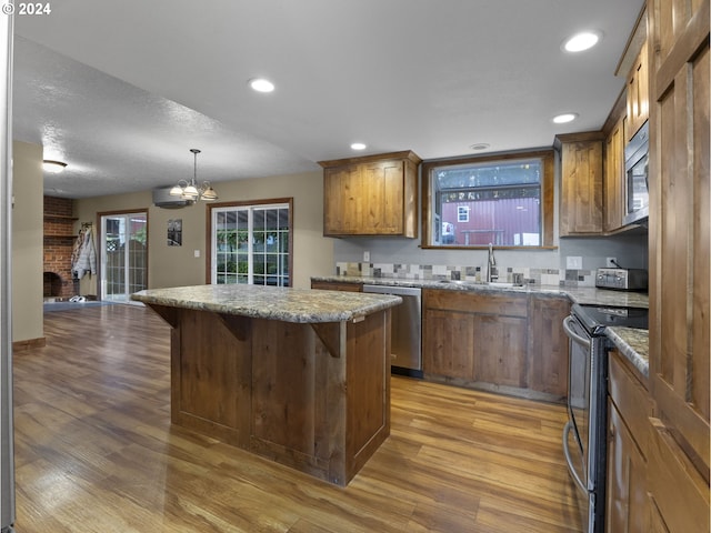 kitchen featuring a kitchen island, a kitchen bar, wood-type flooring, stainless steel appliances, and a chandelier