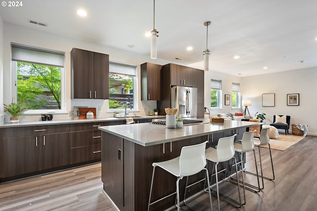 kitchen featuring a kitchen island, light wood-type flooring, and a healthy amount of sunlight