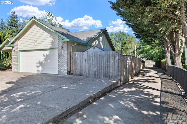 1157 Yew St, Junction City, OR 97448 - view of home's exterior with brick siding, a garage, and driveway