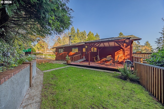 rear view of house featuring a wooden deck and a lawn