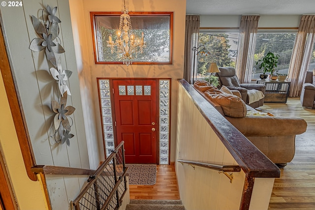 entrance foyer featuring hardwood / wood-style floors, a notable chandelier, and a textured ceiling