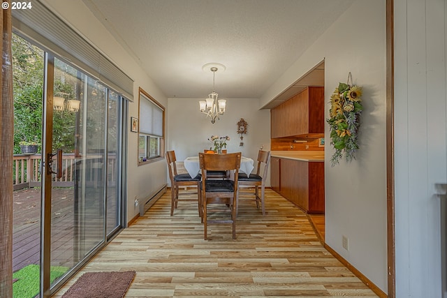 dining room featuring baseboard heating, light hardwood / wood-style floors, a textured ceiling, and a notable chandelier