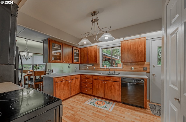 kitchen with sink, tasteful backsplash, pendant lighting, black appliances, and light wood-type flooring