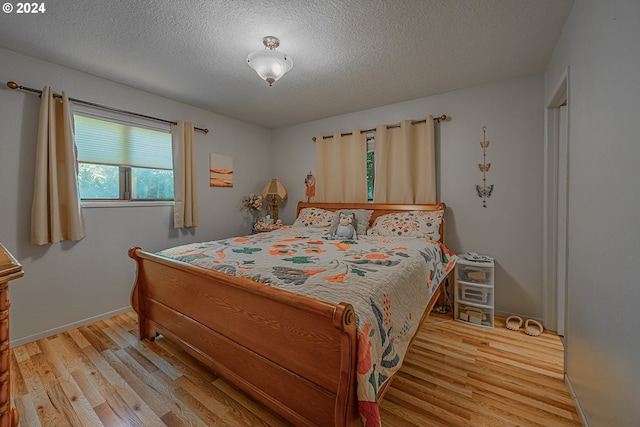 bedroom with wood-type flooring and a textured ceiling