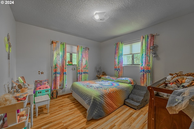 bedroom with light hardwood / wood-style flooring and a textured ceiling