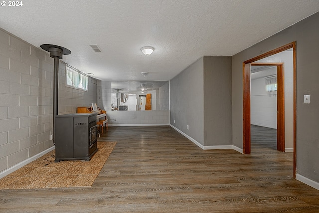 living room with dark hardwood / wood-style flooring, a wood stove, and a textured ceiling