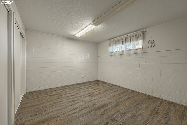 empty room with dark wood-type flooring and a textured ceiling