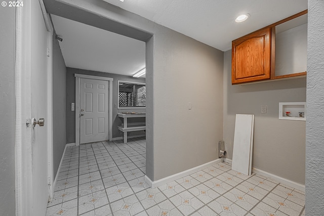 washroom with cabinets, hookup for a washing machine, and light tile patterned floors