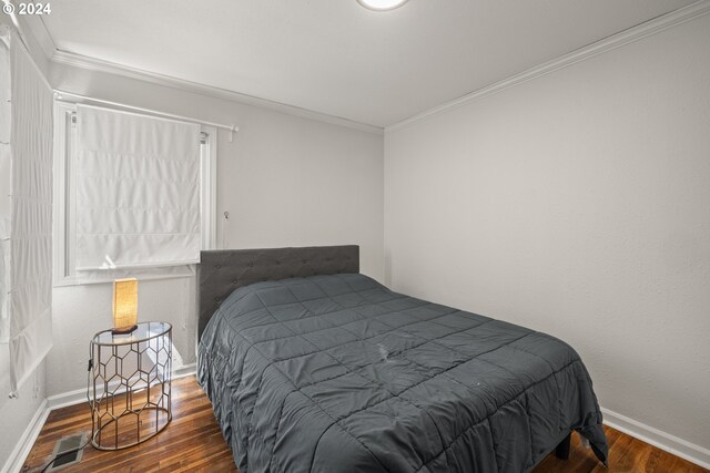 bedroom with crown molding and dark hardwood / wood-style floors