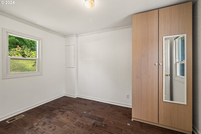 spare room with crown molding and dark hardwood / wood-style floors