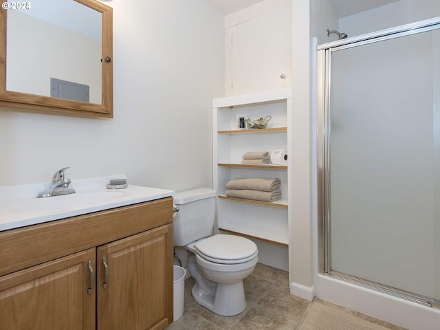 bathroom with a shower with door, vanity, toilet, and tile patterned floors