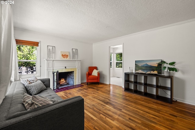 living room featuring dark wood-type flooring, a textured ceiling, plenty of natural light, and a fireplace