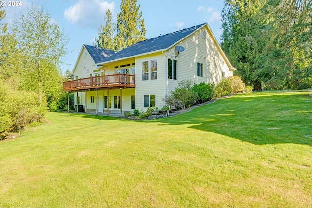 rear view of house featuring central air condition unit, a wooden deck, and a yard