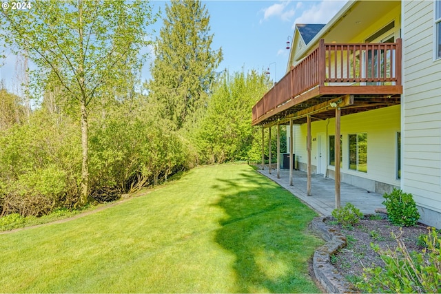 view of yard with central AC and a deck