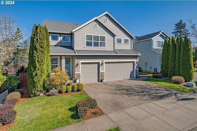 craftsman house with a front yard and a garage