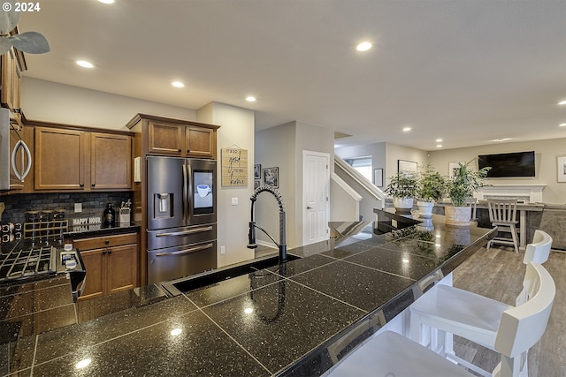 kitchen featuring tasteful backsplash, tile counters, open floor plan, recessed lighting, and appliances with stainless steel finishes