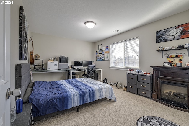 bedroom with visible vents, a textured ceiling, and carpet floors