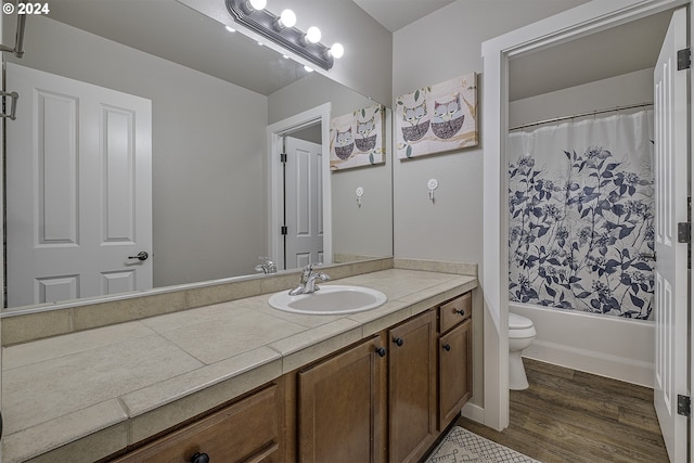 full bath featuring shower / tub combo with curtain, toilet, vanity, and wood finished floors