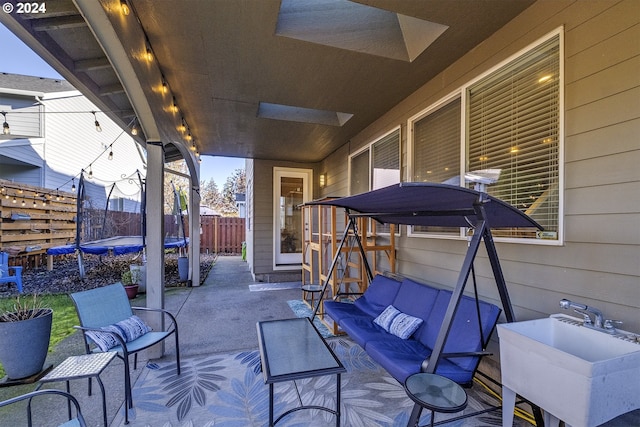 view of patio / terrace with outdoor lounge area, a trampoline, and sink