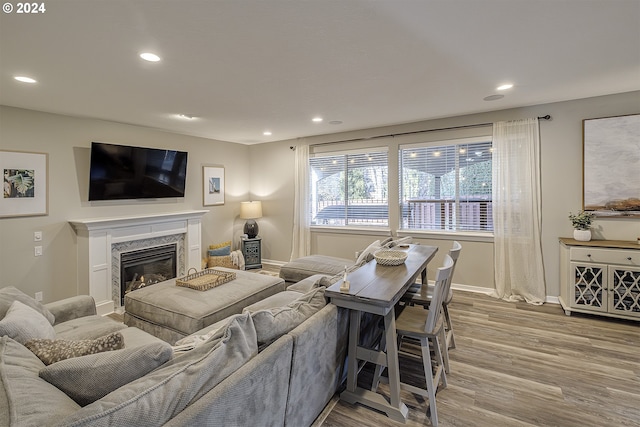 living room with light hardwood / wood-style flooring and a high end fireplace