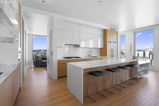 kitchen with white cabinetry, a center island, light hardwood / wood-style floors, and gas stovetop