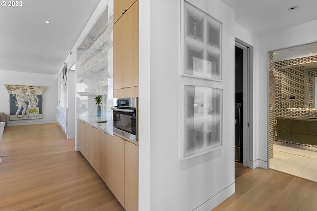 corridor with light hardwood / wood-style floors