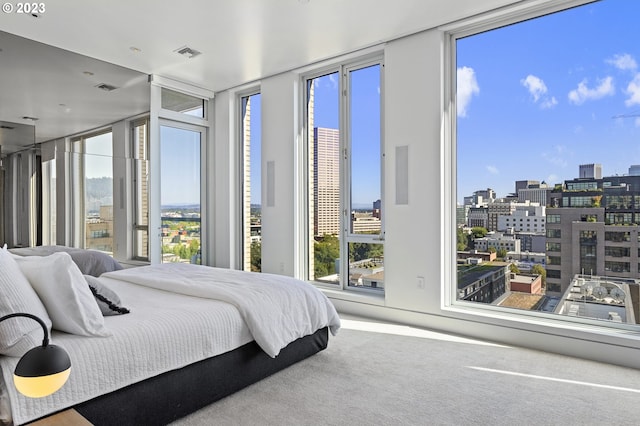 carpeted bedroom featuring access to exterior and a wall of windows