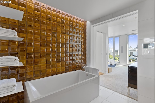 bathroom with tile patterned flooring and a tub to relax in