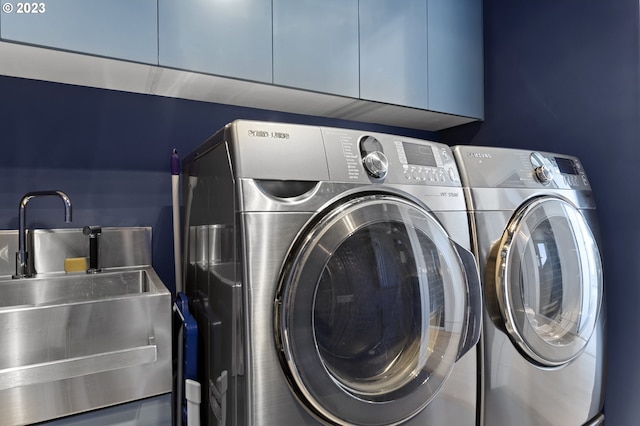 laundry area featuring cabinets, washing machine and dryer, and sink