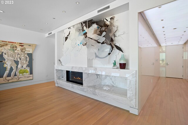 interior space featuring wood-type flooring and a high end fireplace