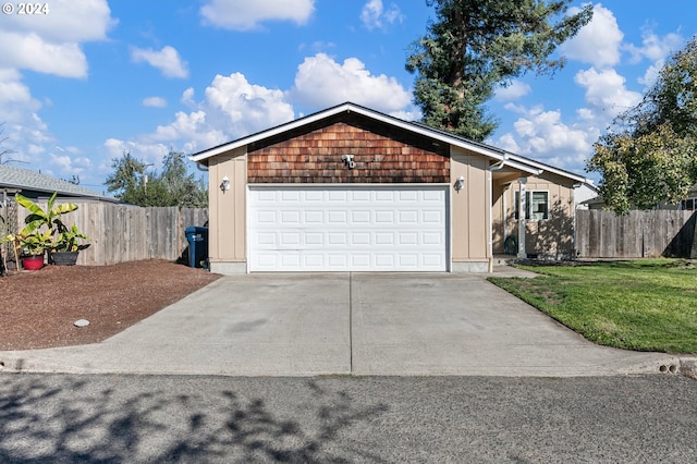 garage featuring driveway and fence