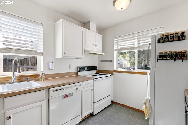kitchen featuring white cabinetry, white appliances, baseboards, under cabinet range hood, and a sink